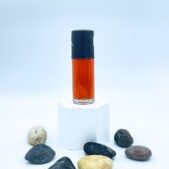 Small amber bottle on pedestal with stones