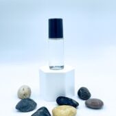 Clear glass bottle on pedestal with stones