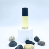Glass oil bottle on pedestal with surrounding stones